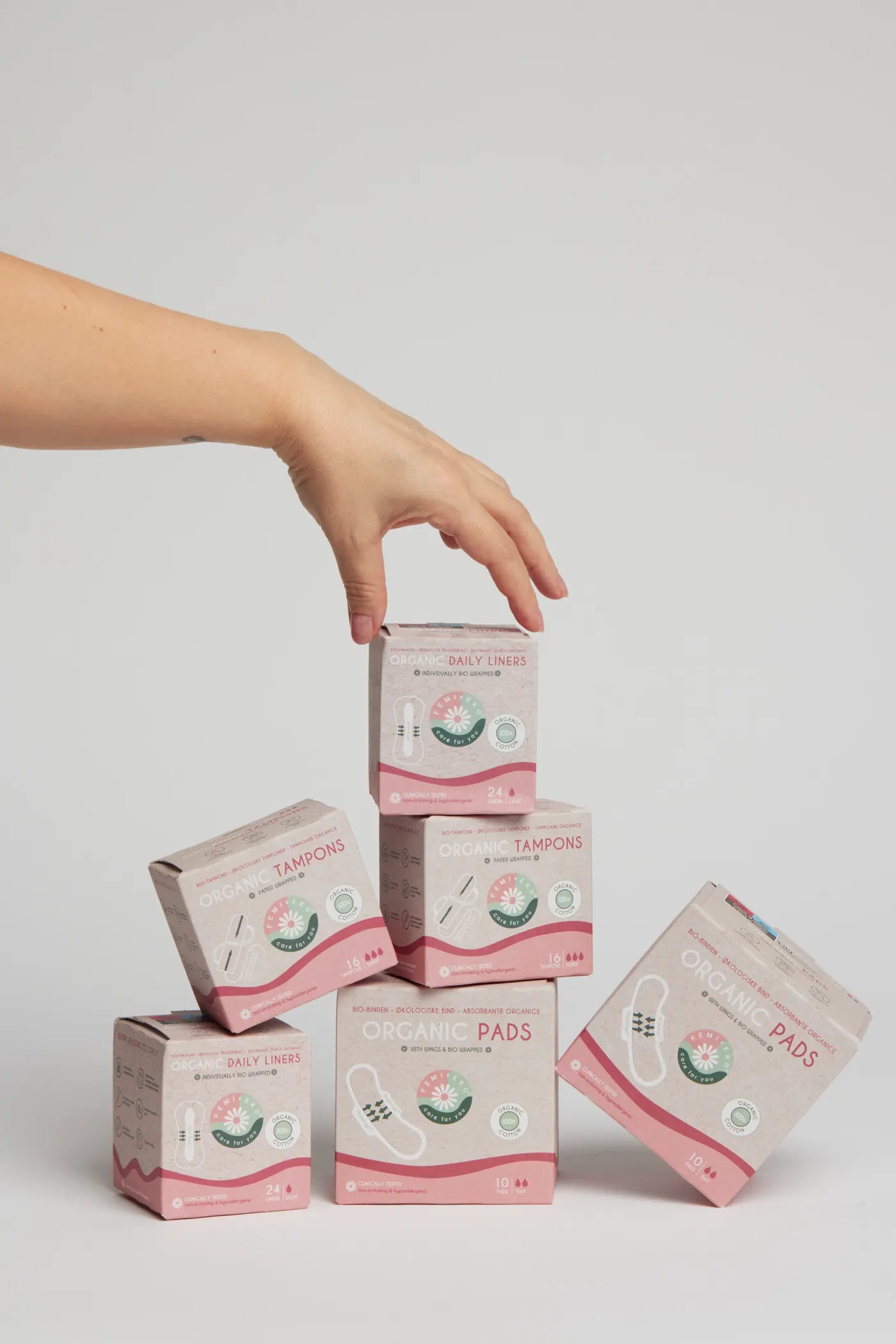 Askar med Femieko bindor, tamponger och trosskydd staplade i en produktkomposition