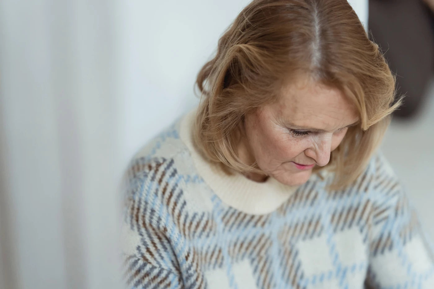 Mogen kvinna i ett lugnt ögonblick hemma i naturligt ljus